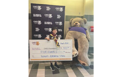 Presenting the check to CHEO is Felix, representing the Beavers.