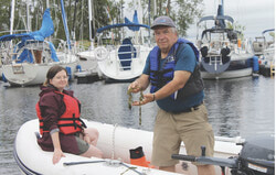 Biologists Pascal Samson and Marion Duflos at the Aylmer Marina holding a sample of Eurasian Watermilfoil, an invasive species widespread throughout the region. Photo: Greg Newing