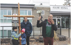 Good Friday, April 3, this year, is the day parishioners carry the cross. Pictured here are, from left, Max, Caesar and their father Adrian Alvarez, as well as Pontiac MP Greg Fergus. Photo: Jude Osmond